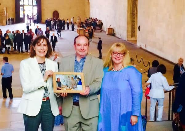 MP Victoria Atkins (left) with Russ and Sadie and the framed photo EMN-160809-162906001
