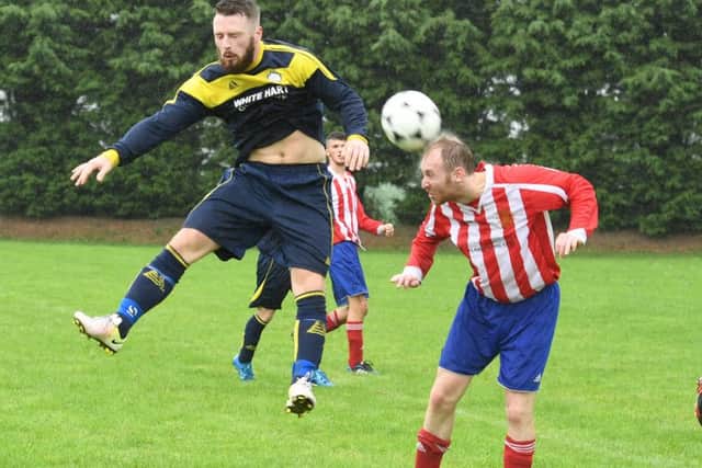 Old Leake's Adam Abell and Swineshead's Callum Simmons challenge for the ball.