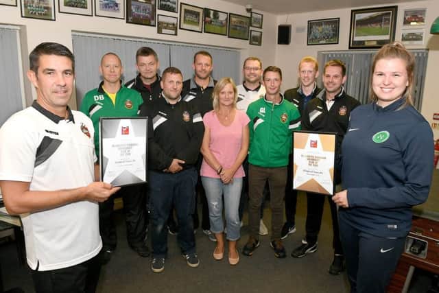 Sleaford Town JFC chairman Jason Butler receiving the awards from Lincs Football Association football development officer Sophie Bartu, pictured with Sleaford Town JFC development committee members. Photo: David Dawson
