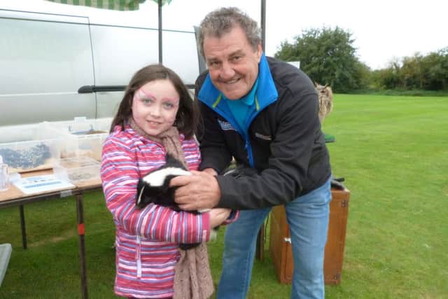 Jessica Harvey holding Debs the Skunk with Tony Butler of Exotic Animals and Owl Encounters. EMN-160921-170523001