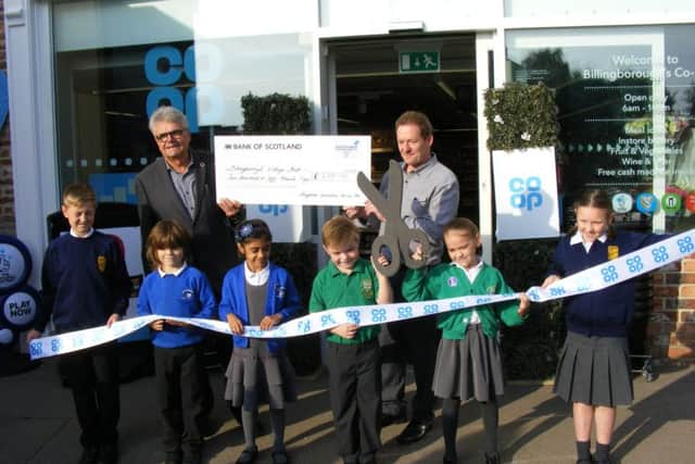 Local school children attend the re-launch of Billingboroughs new look Co-op store, pictured with Malcolm Barlow of Billingborough village hall and Robert Wynne of Kingfisher Construction. EMN-161014-142818001