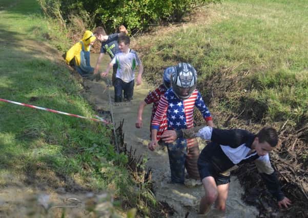 Boys wade through the muddy ditch obstackle on the Sir William Robertson Academy Mudathon. EMN-161110-122719001