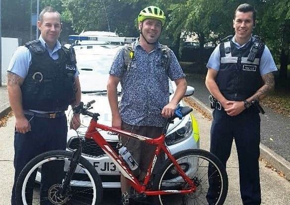 Colin Mackinder is greeted by military police officers on his route through RAF Cranwell on his bike ride. EMN-161013-174322001