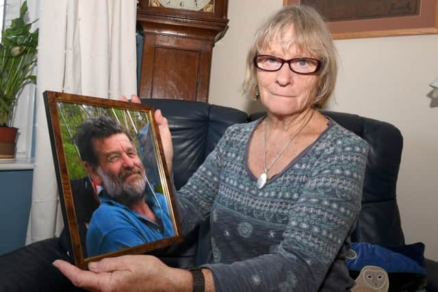 Sandra Hather of Huttoft whose husband died of a heart attack on board their catamaran moored off Gibraltar Point. Pictured looking at photographs of her husband.