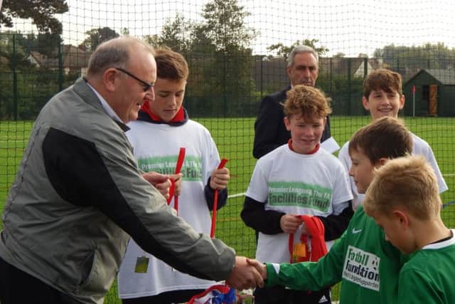 Carre's Grammar School governor John Boyce hands out medals to youngsters competing in a local football tournament to mark the opening.