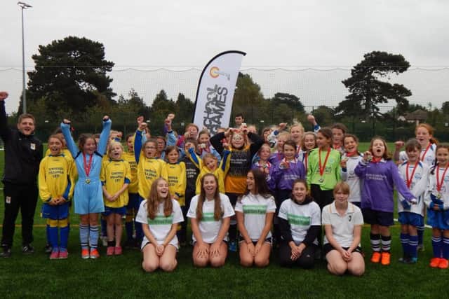 Carre's Grammar School games organiser Matthew Evans celebrates the opening of the new 3G pitch alongside the primary school's football teams.