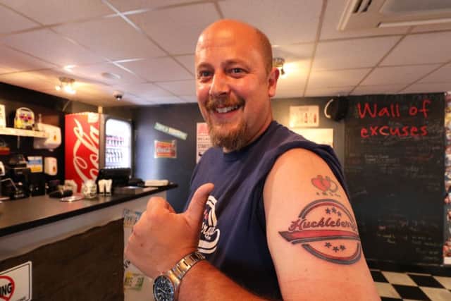 Tony Virr, 44, of Skegness, with his Huckleberry's tattoo (seen here beneath a pre-existing tattoo).
