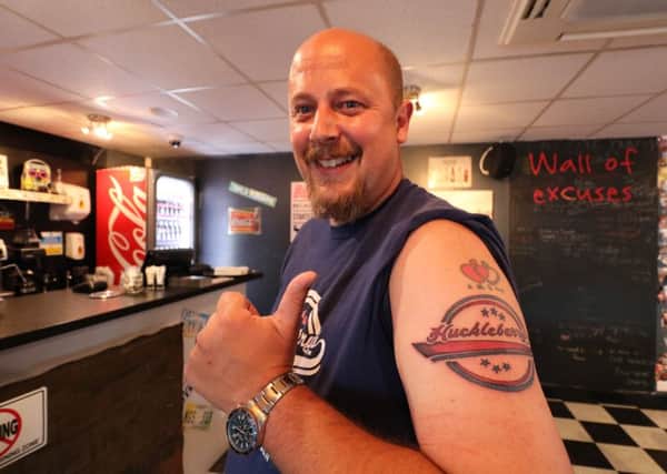 Tony Virr, 44, of Skegness, with his Huckleberry's tattoo (seen here beneath a pre-existing tattoo).