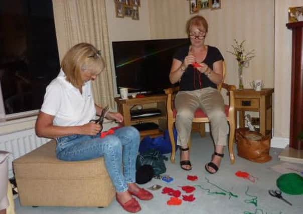 Members of Sleaford Lionesses knitting 27 poppies for the poppy appeal. EMN-161031-141426001