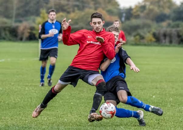 Coningsbys Shaun Boothby came off best in this encounter during the league match with Pointon on Saturday, scoring the first three goals for the Red. Photo: Oscarpix Imaging