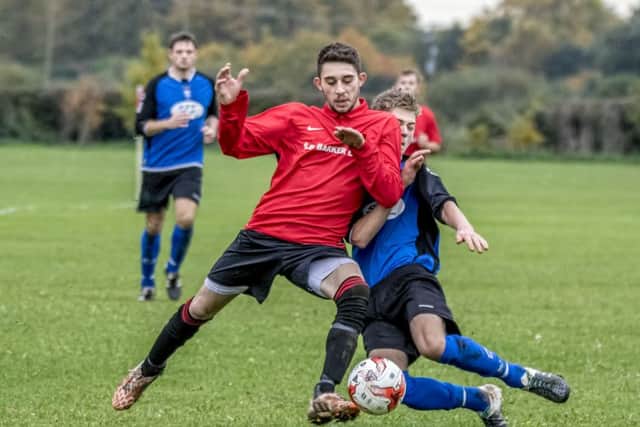 Coningsbys Shaun Boothby came off best in this encounter during the league match with Pointon on Saturday, scoring the first three goals for the Red. Photo: Oscarpix Imaging