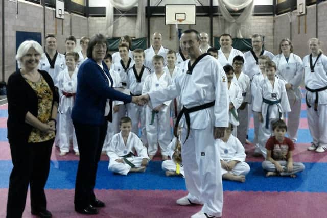 Taekwondo groups hand over the cheque.