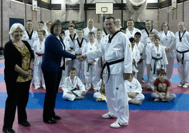 Taekwondo groups hand over the cheque.