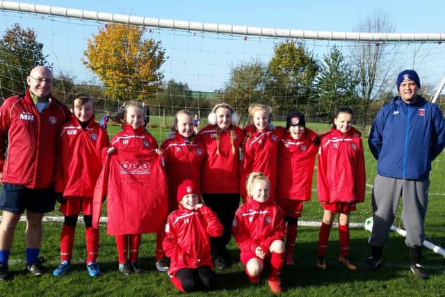 Horncastle Town U12 Girls wearing their new sponsored rain jackets from Brian Stokle (right) of BLS Roofing and PVCu Roofing Specialist, and Neil Paxton of NCP Painting and Decorating.