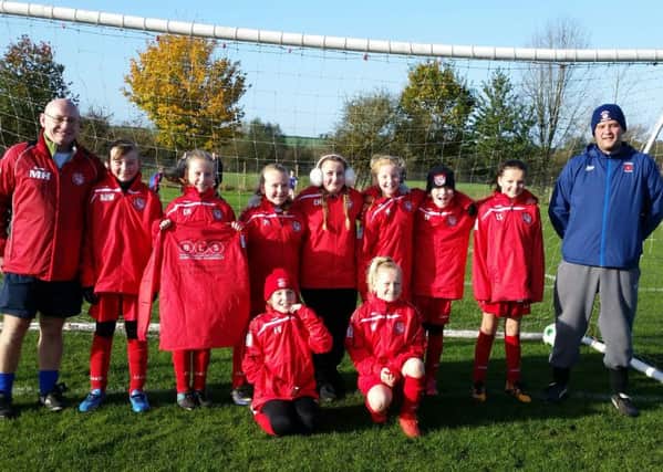 Horncastle Town U12 Girls wearing their new sponsored rain jackets from Brian Stokle (right) of BLS Roofing and PVCu Roofing Specialist, and Neil Paxton of NCP Painting and Decorating.