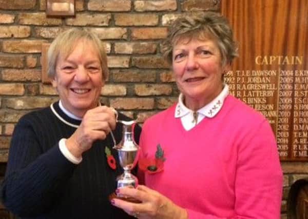 Lady Captain Kath Yates is seen presenting the Ted Eaglen Trophy to Jean Markham.