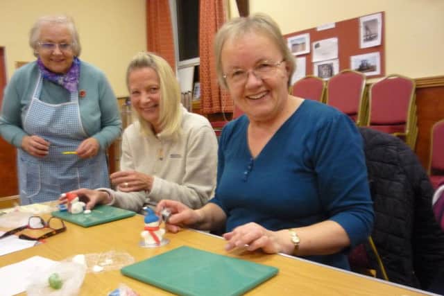 Kathy Shaw and Julie Chandler try their hand at sugarcraft snowmen, under the watchful eye of Lynn Larder. EMN-161115-165052001