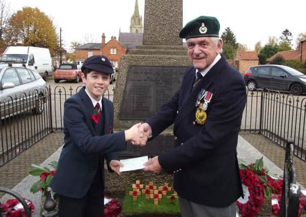James Burrell presents the proceeds of his poppy sales to Mike warrington, chairman of teh Heckington branch of the British Legion. EMN-161121-180208001