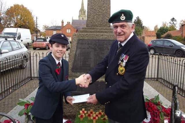 James Burrell presents the proceeds of his poppy sales to Mike warrington, chairman of teh Heckington branch of the British Legion. EMN-161121-180208001