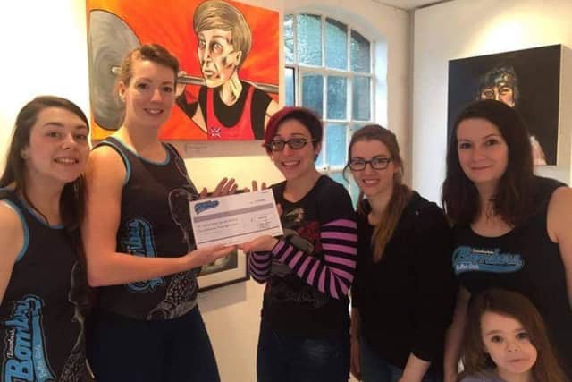 The Lincolnshire Bomber Roller Girls presenting a cheque to artist Mel Langton. Credit Peter Worth EMN-161123-100743001