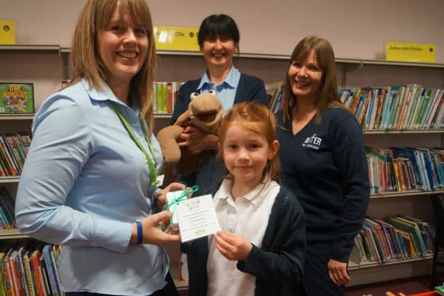 Emma Gisising receives her prize from the Summer Reading Challenge draw EMN-160412-072146001