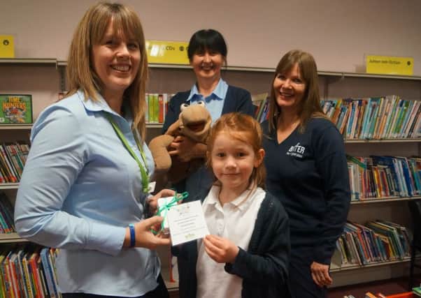 Emma Gisising receives her prize from the Summer Reading Challenge draw EMN-160412-072146001