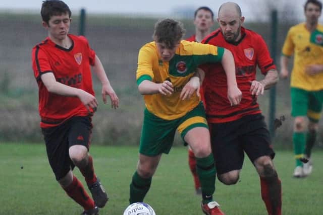 Thomas Moor (right) and Jack Padley of Sleaford Sports Amateurs put Skegness Town's Morgan Coombes under pressure. Photo: Nigel West