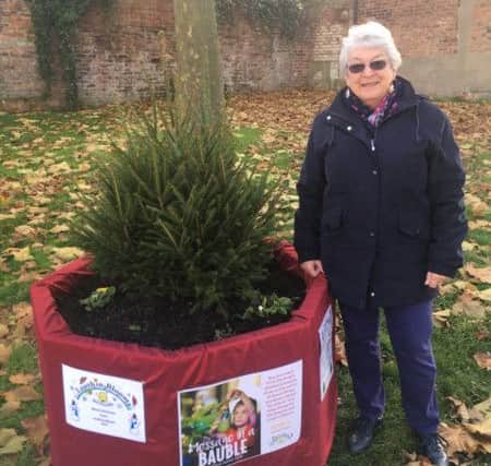 Louth In Bloom chairman, Sue Crew, with one of the Christmas Trees at the Kidgate/Aswell Street junction.