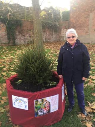 Louth In Bloom chairman, Sue Crew, with one of the Christmas Trees at the Kidgate/Aswell Street junction.
