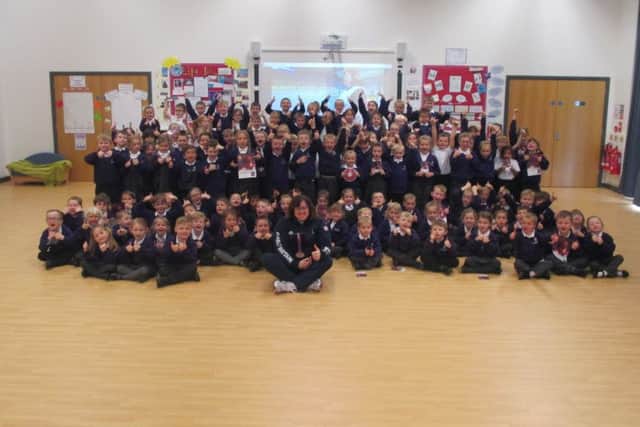 Beverly Jones MBE pictured with all the pupils at Beacon Primary Academy.