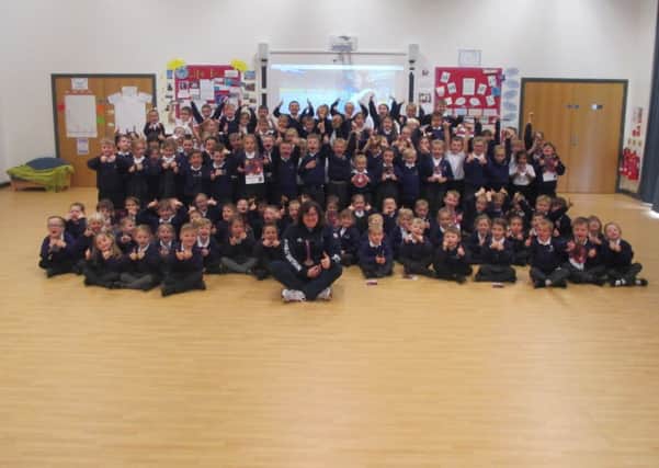 Beverly Jones MBE pictured with all the pupils at Beacon Primary Academy.