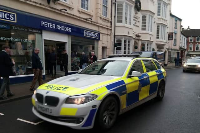 Police cars leave the scene in Mercer Row this aftenoon (December 9).
