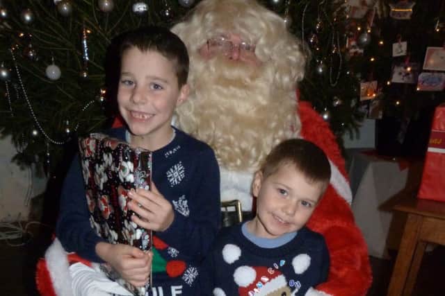 Alfie Davis (left) and Finley Lewis receiving their presents from Santa