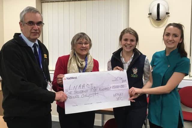 Air ambulance representatives Geoff and Anne Crawforth receive the cheque from Wragby Young Farmers members Alex Olivant and Charlotte Littleworth. EMN-161229-094620001