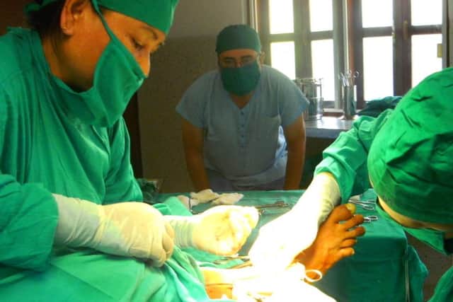 Richard Waller looks on as surgeons operate on a patient