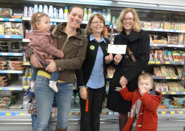 Emma Dix, right, and Freddie receiving the cheque from Debbie McKitton with Rachel Pettifer, Anna (1) and Oustin (3) at Caistor Co-op EMN-171001-162745001