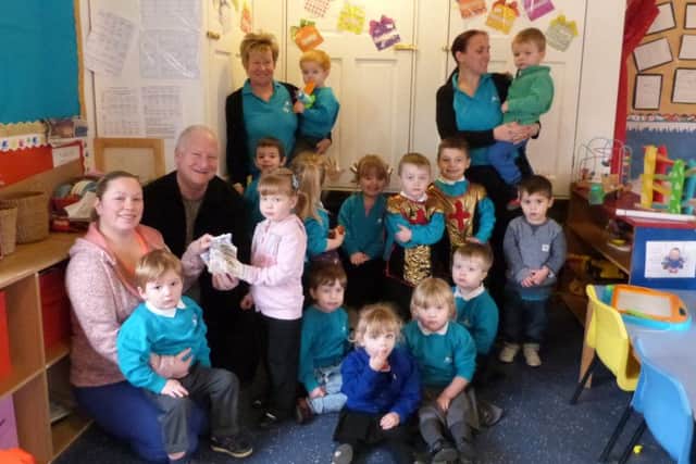Treasurer Debbie Andrews receives the cheque from Steve Hannibal, watched by Kath Pearson, Kerry Parrott and the Rainbow children. (Lin) EMN-170115-082245001