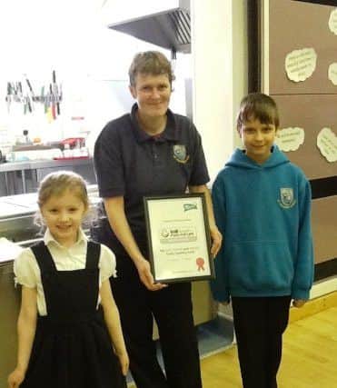 Mrs Wilkinson (Cook in Charge), with the youngest and oldest school councillors, Farrah Cammack (Reception) and Jack Burrage (Year 6)