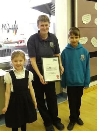 Mrs Wilkinson (Cook in Charge), with the youngest and oldest school councillors, Farrah Cammack (Reception) and Jack Burrage (Year 6)