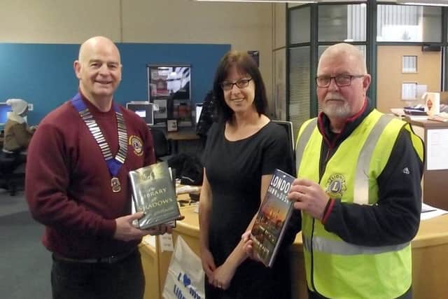 Horncastle Lions President Steve Flood and Vice President Tom Rayner. present the books to Donna Starling (Customer Services Advisor) EMN-170127-185114001
