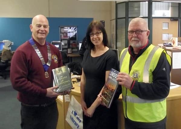 Horncastle Lions President Steve Flood and Vice President Tom Rayner.  present the books to Donna Starling (Customer Services Advisor) EMN-170127-185114001