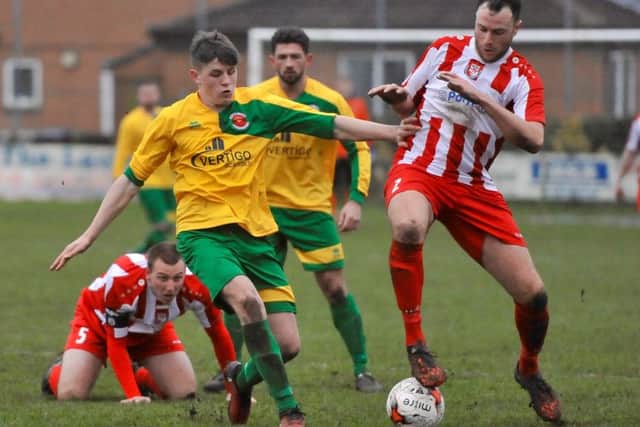 Skegness Town's George Hobbins challenges Horncastle Town's Nathan Rawdon for the ball.