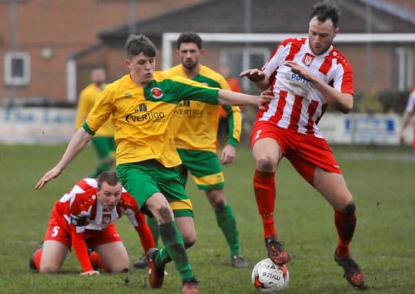Skegness Town's George Hobbins challenges Horncastle Town's Nathan Rawdon for the ball.