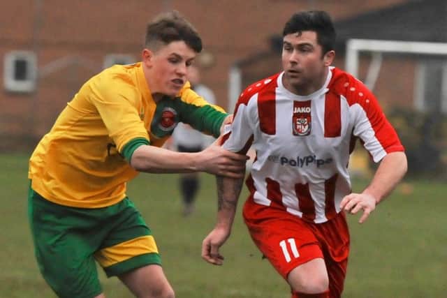 Horncastle Town's Scott Lowman shrugs off the challenge of Skegness Town midfielder George Hobbins.
