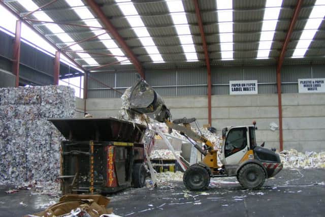 A baler is loaded with labelling waste to be recycled. EMN-170124-172917001