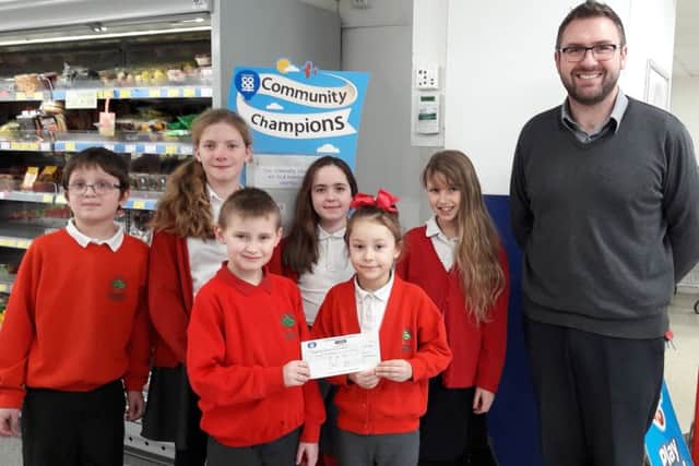 Thomas, Freya, Zofia, Giorgina, Kaylun and Roslyn with Co-Op staff and a cheque for ?417.14 EMN-170602-102722001