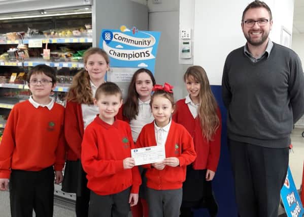 Thomas, Freya, Zofia, Giorgina, Kaylun and Roslyn with Co-Op staff and a cheque for ?417.14 EMN-170602-102722001
