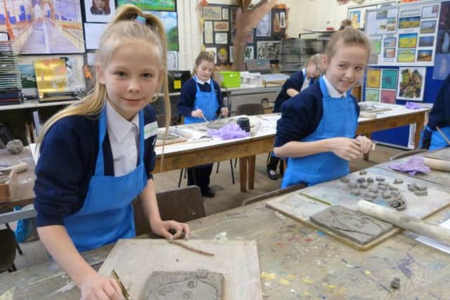 Hannah Coupland and Lily Atkinson working on the clay plaques. (photo by Linda Oxley) EMN-170215-124532001