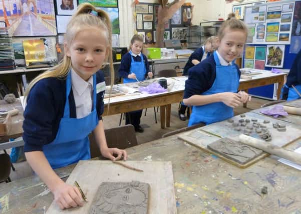 Hannah Coupland and Lily Atkinson working on the clay plaques. (photo by Linda Oxley) EMN-170215-124532001