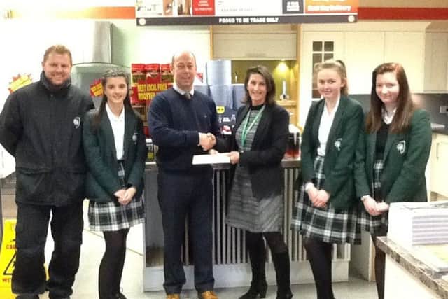 Howdens Joinery Company presenting the cheque to Mrs Pankhurst, head of technology pictured with pupils. EMN-170227-154254001